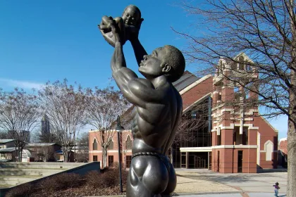 Statue of a man holding a small baby up to the sky