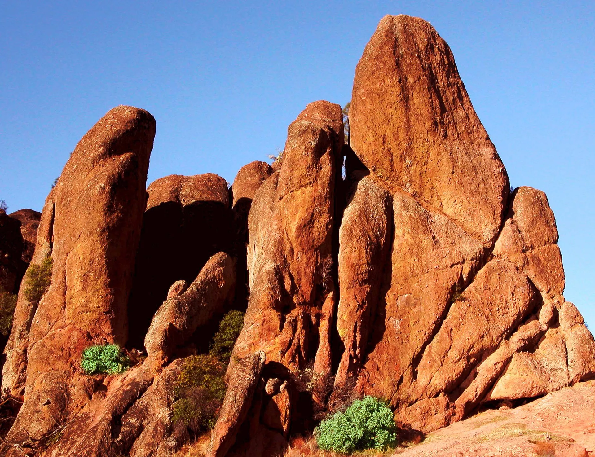 Bright red rocks jut upwards from the ground into the sky
