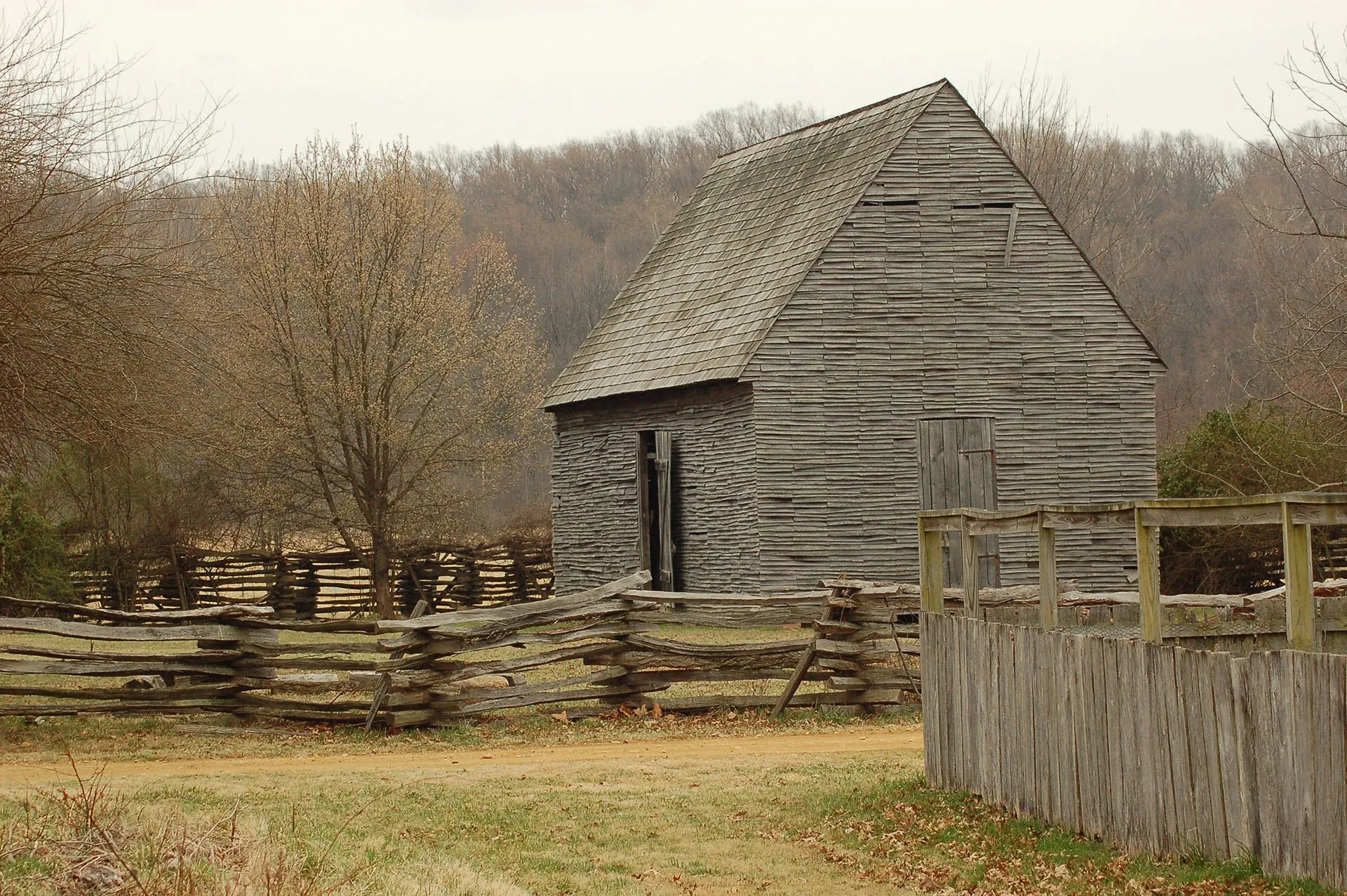 Historic cross hatch log fences and a wooden clapboard house