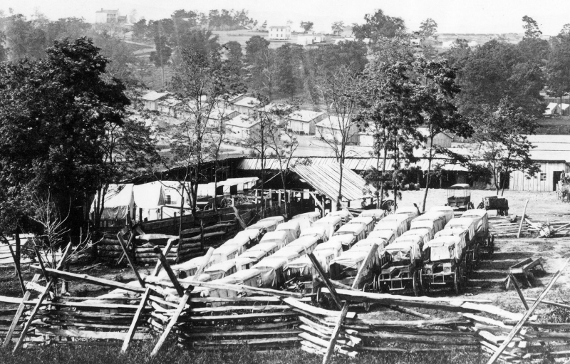Historic black and white photo of vehicles and barracks at Camp Nelson National Monument