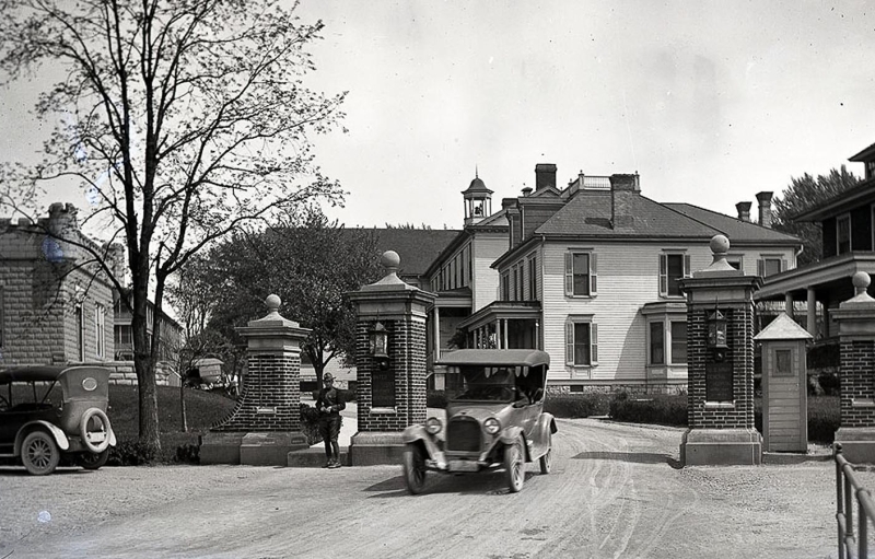 Historic image of Carlisle Federal Indian Boarding School and several cars on the road outside the building