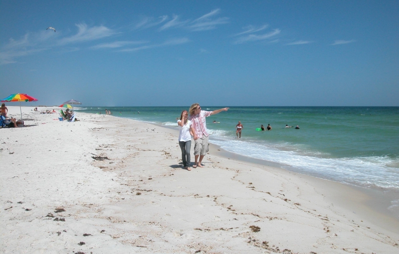 Mujer apuntando hacia el océano mientras caminaba por el Gulf Islands National Seashore