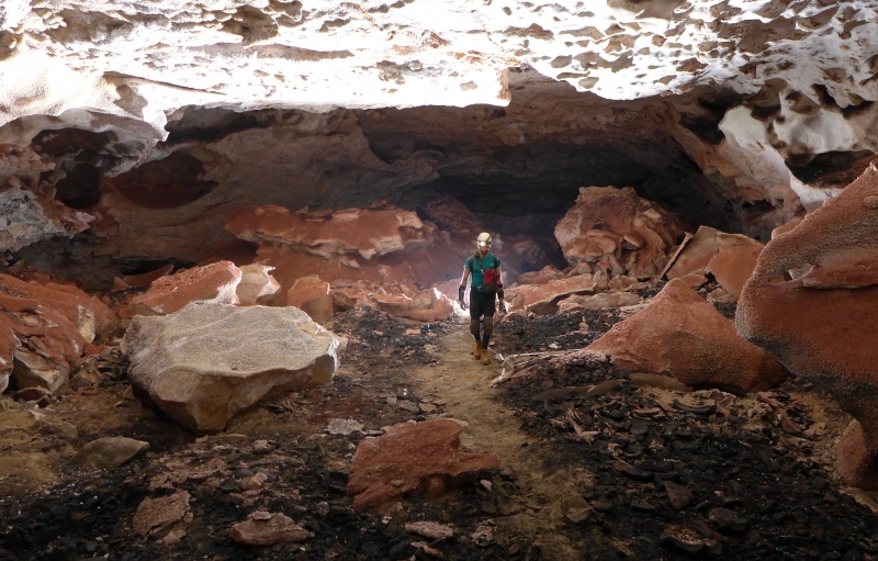 Caver standing in a large passage on an exploration trip