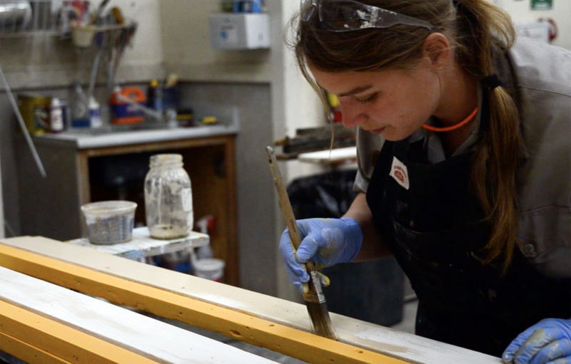 Trabajador de pintura Michelle Harris tableros de pintura en el Parque Histórico Nacional Klondike Goldrush