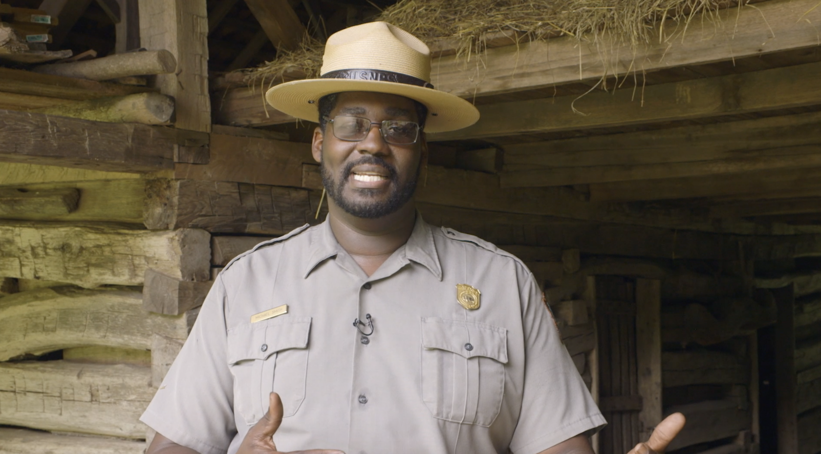 NPS employee Michael Smith stands in uniform and smiles at the camera