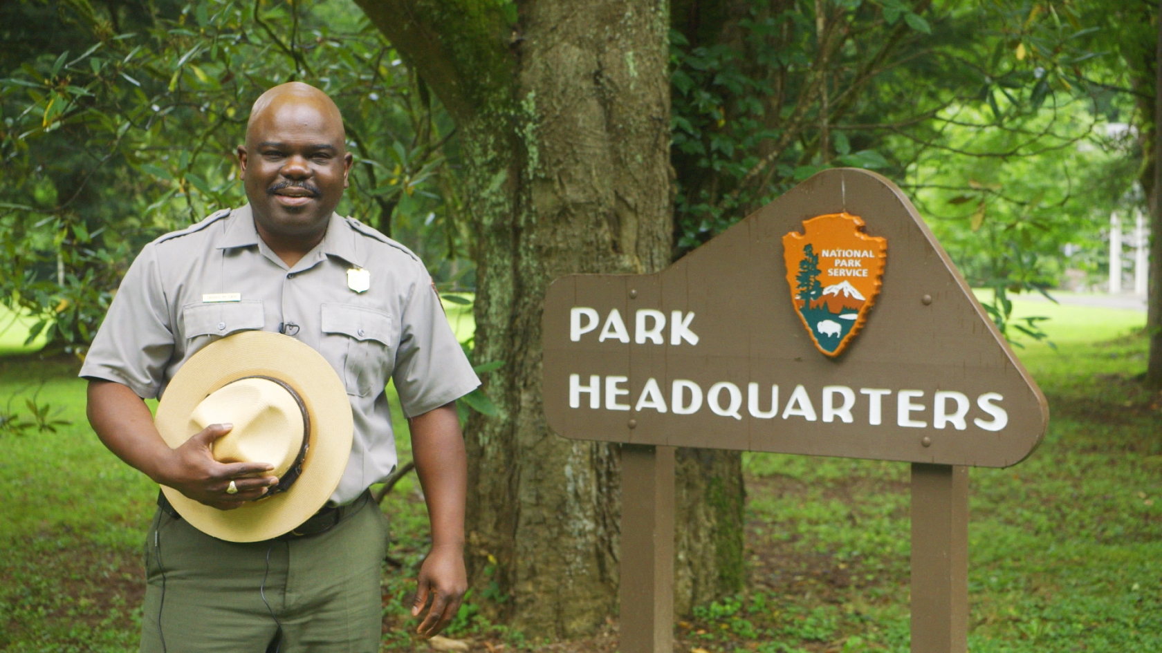Superintendent Cassius Cash stands next to the park headquarters sign