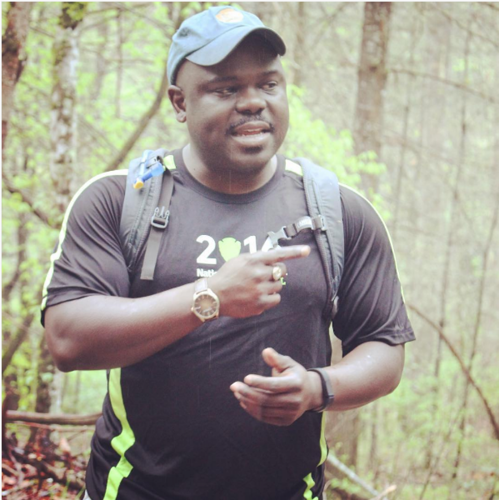 Park ranger where backpack and pointing at the forest while hiking