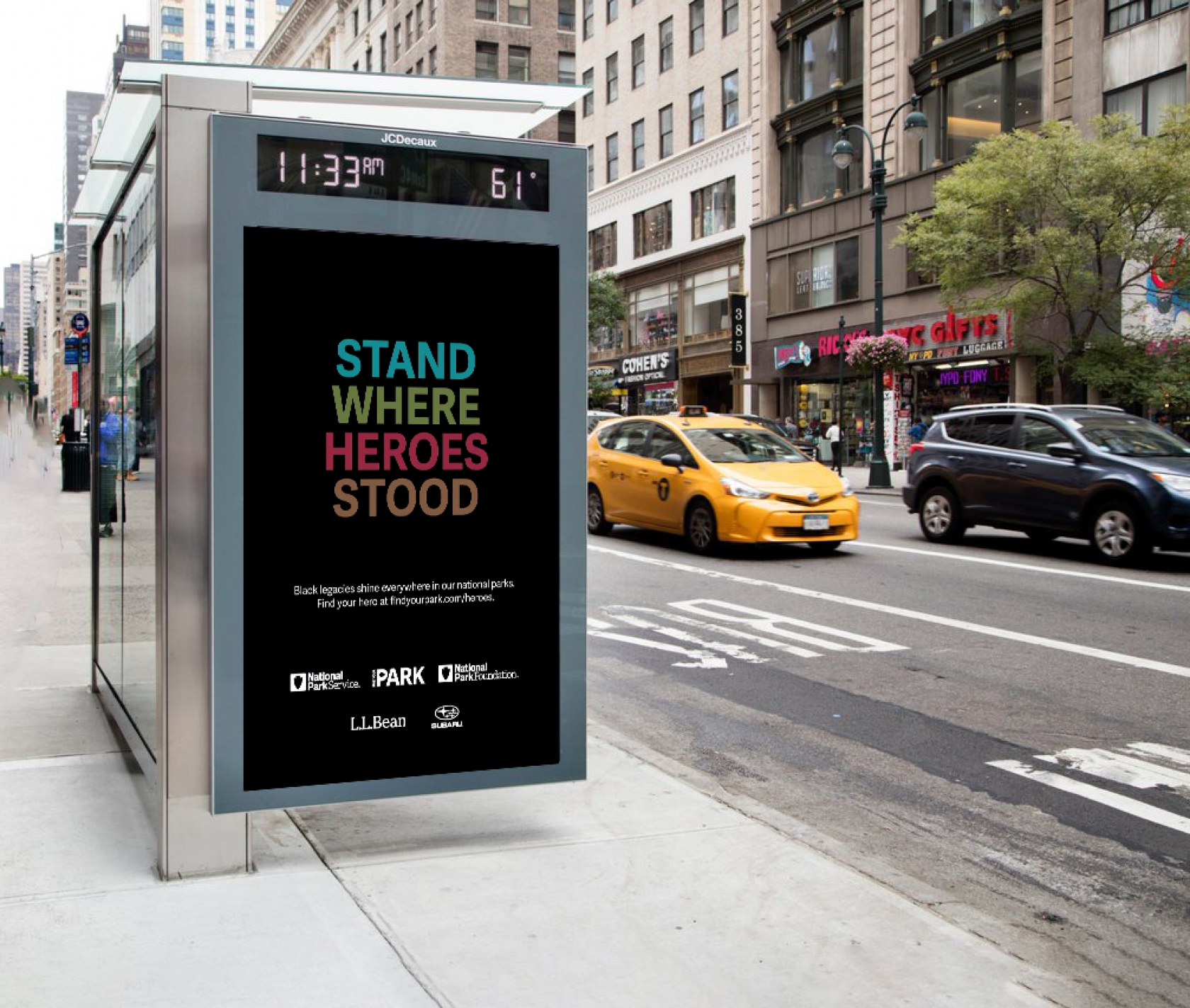 A poster on a bus stop reads "Stand Where Heroes Stood"