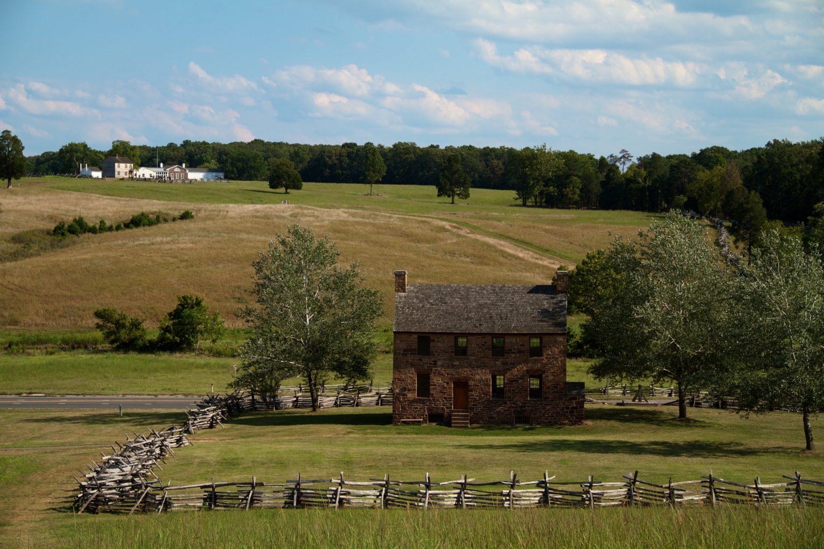 Virginia's Manassas National Battlefield Park, old stone house and trees line the green hills.