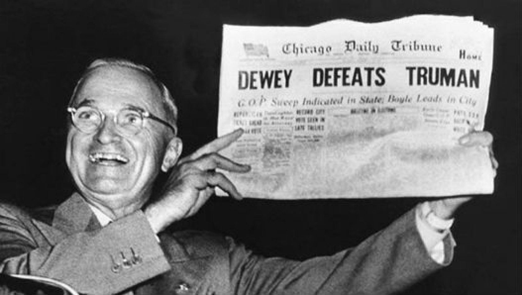 Truman holding a newspaper that says Dewey defeated him