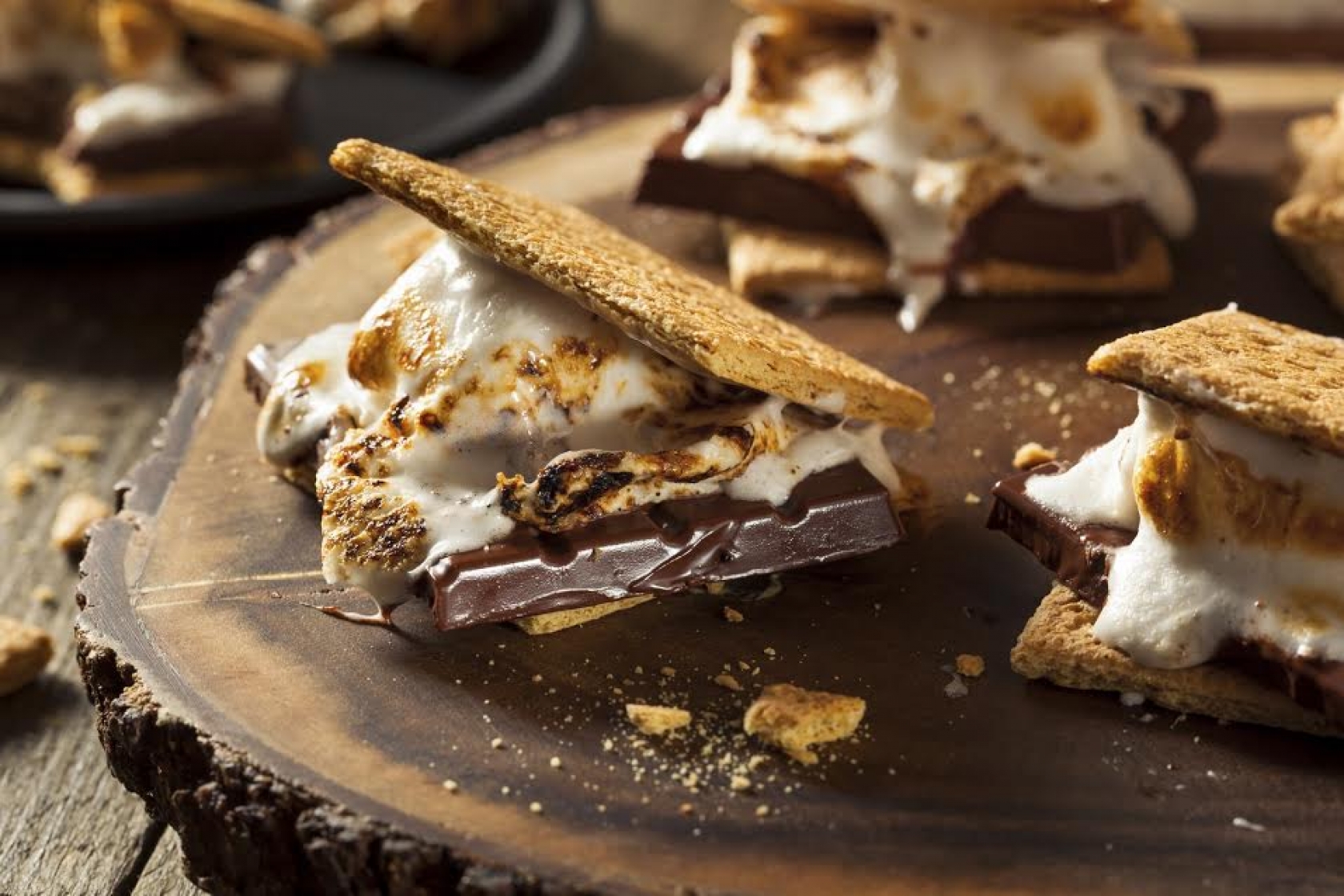 Gooey chocolate marshmallows s'mores sit on plate. 