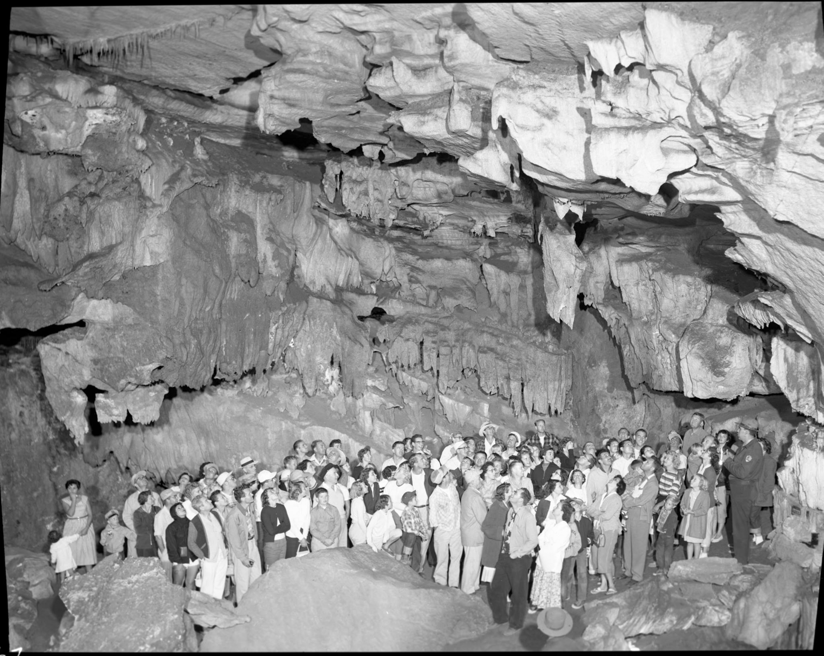 Black and white photo of a large group of people inside Crystal Cave in 1955 at Sequoia and Kings Canyon National Park