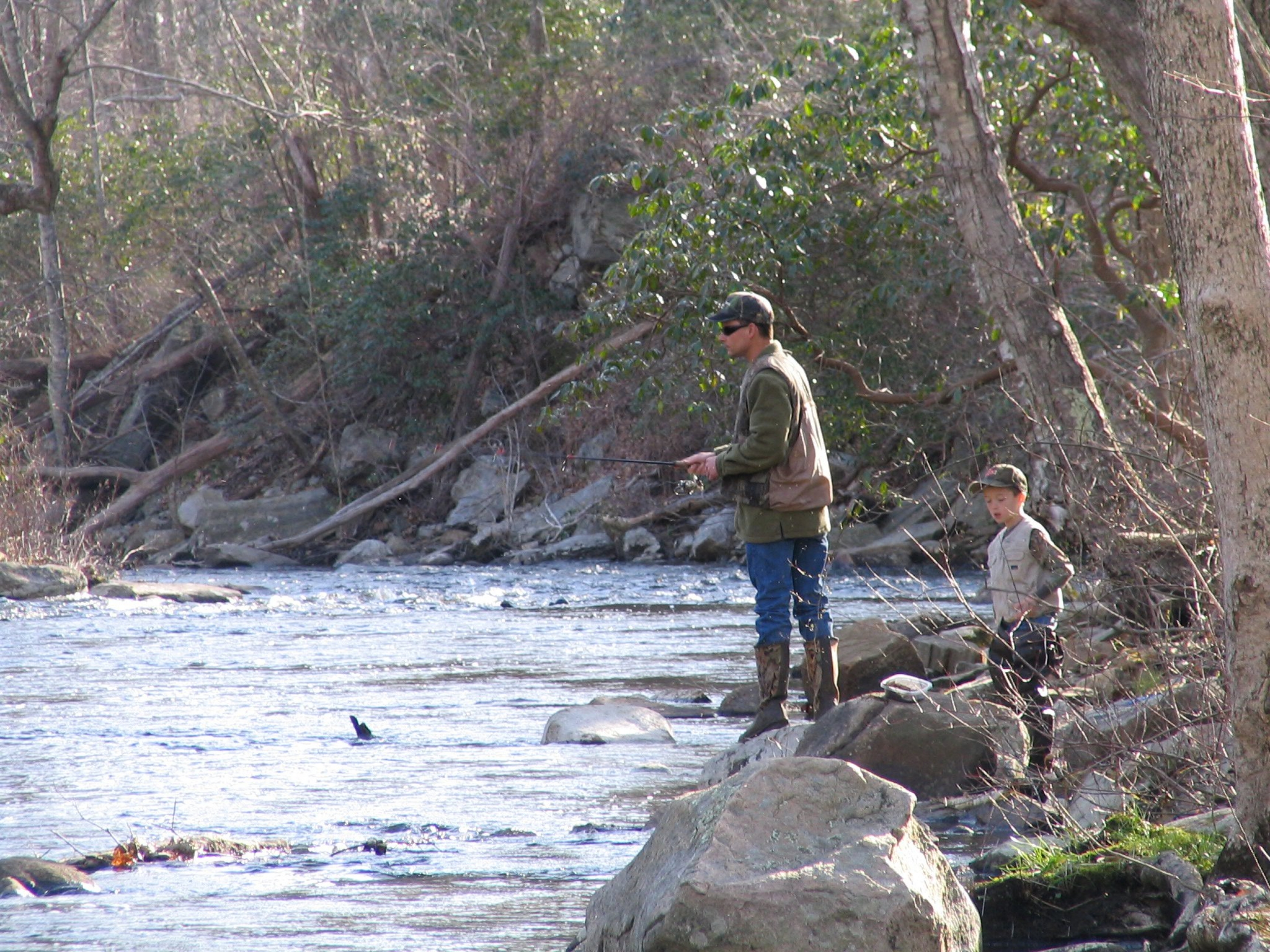 Anciano y niño pequeño que pescan a lo largo del río Eightmile