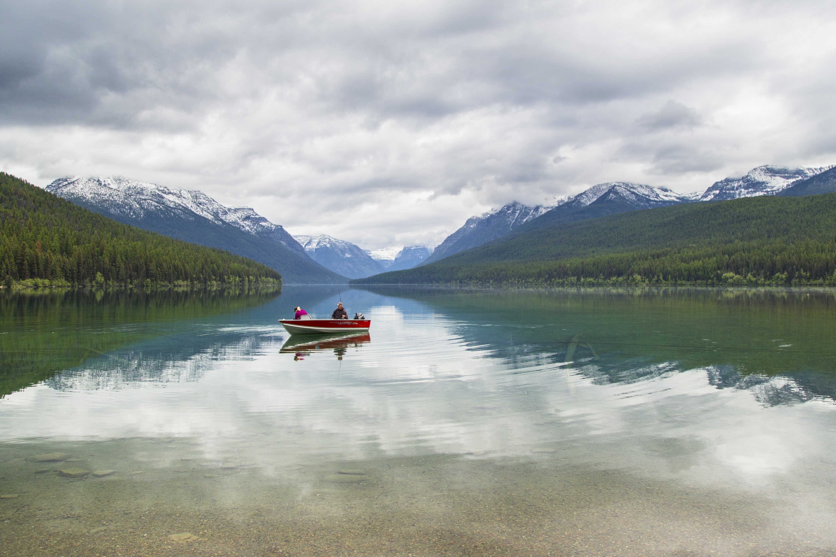 Boaters in a red boat on Bowman Lake at Glacier National Park