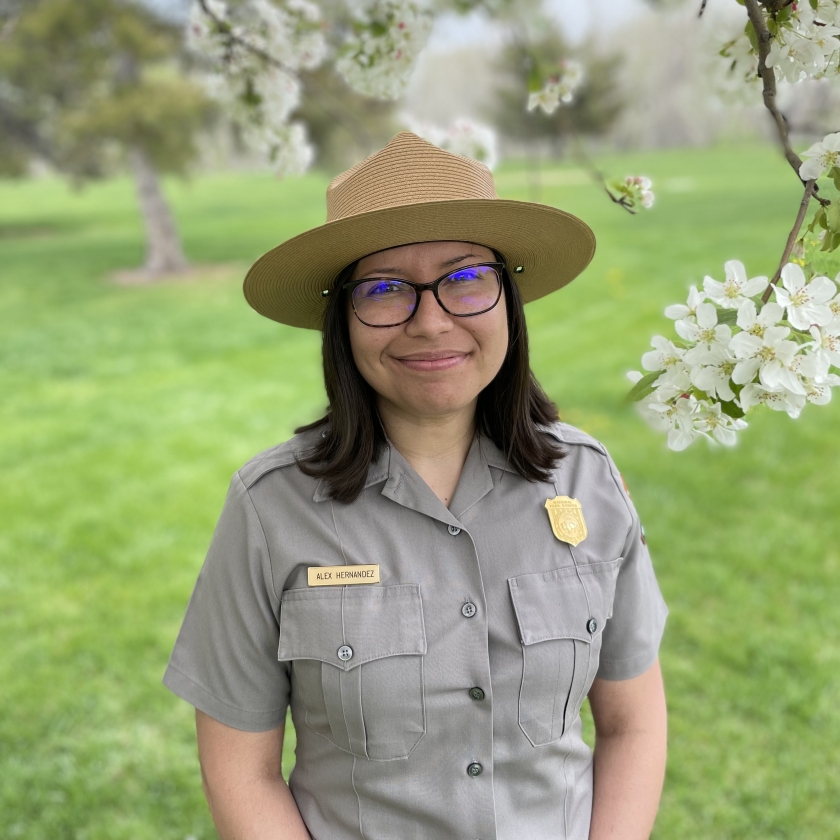 Alex Hernandez, in uniform, stands under a blossoming tree