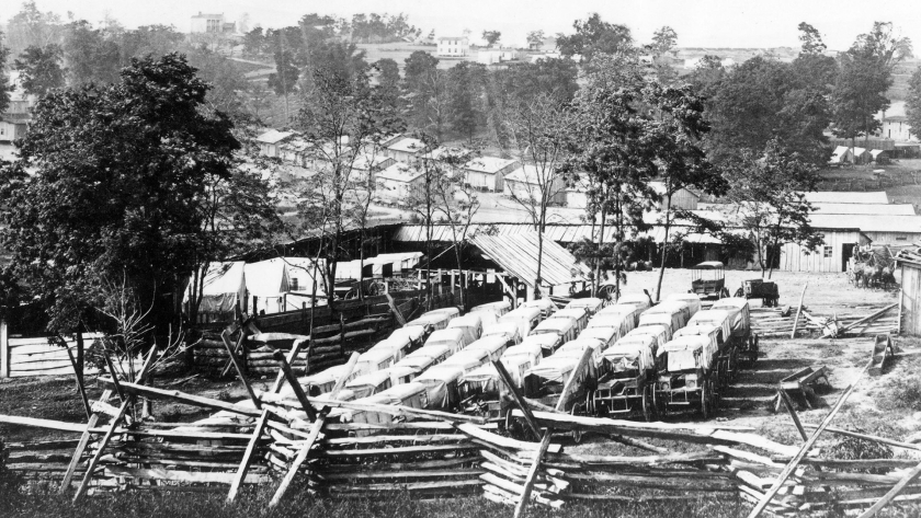 Historic black and white photo of vehicles and barracks at Camp Nelson National Monument