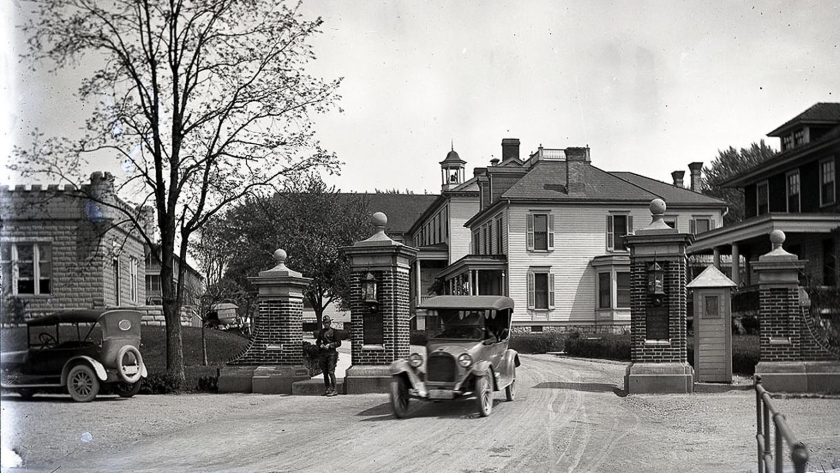 Imagen histórica del internado indígena federal de Carlisle y varios automóviles en la calle frente al edificio