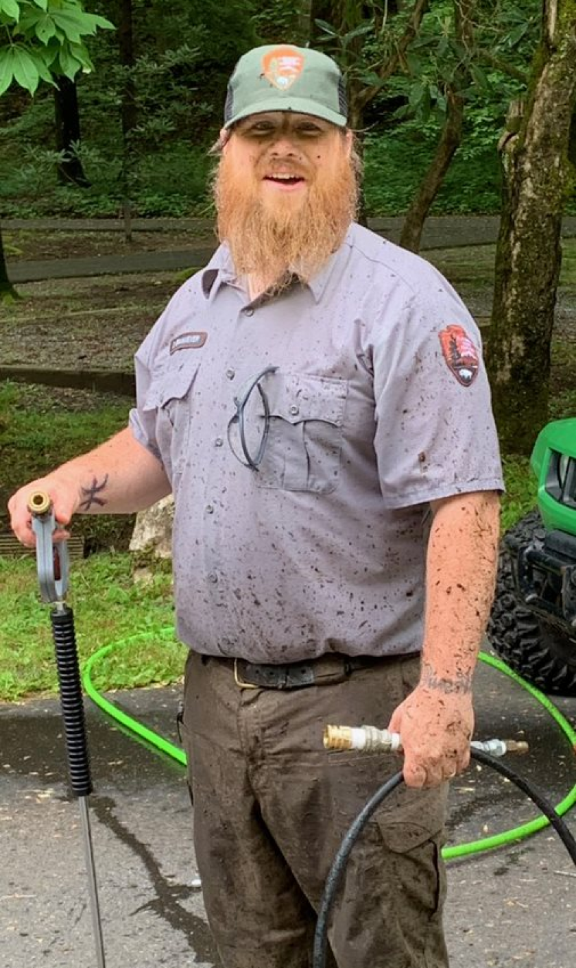 Darin Brinkmeyer smiles for a picture, splattered with dirt from a day's work