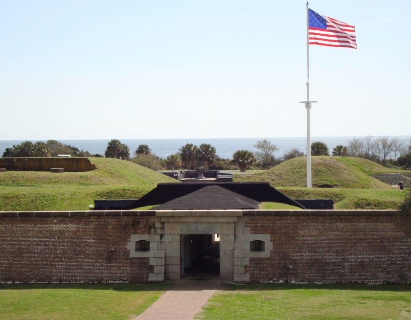 Brick fort entrance to Fort Moultrie with a flag waving at the entrance