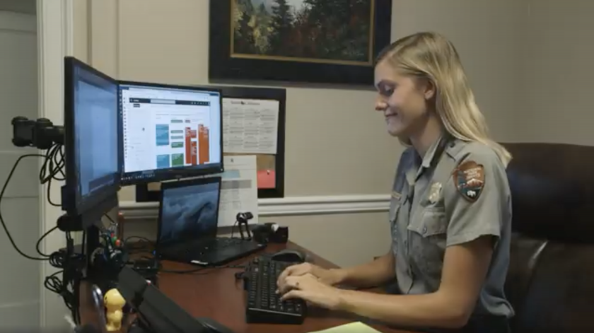 Jessie Snow, in NPS uniform, works at a computer