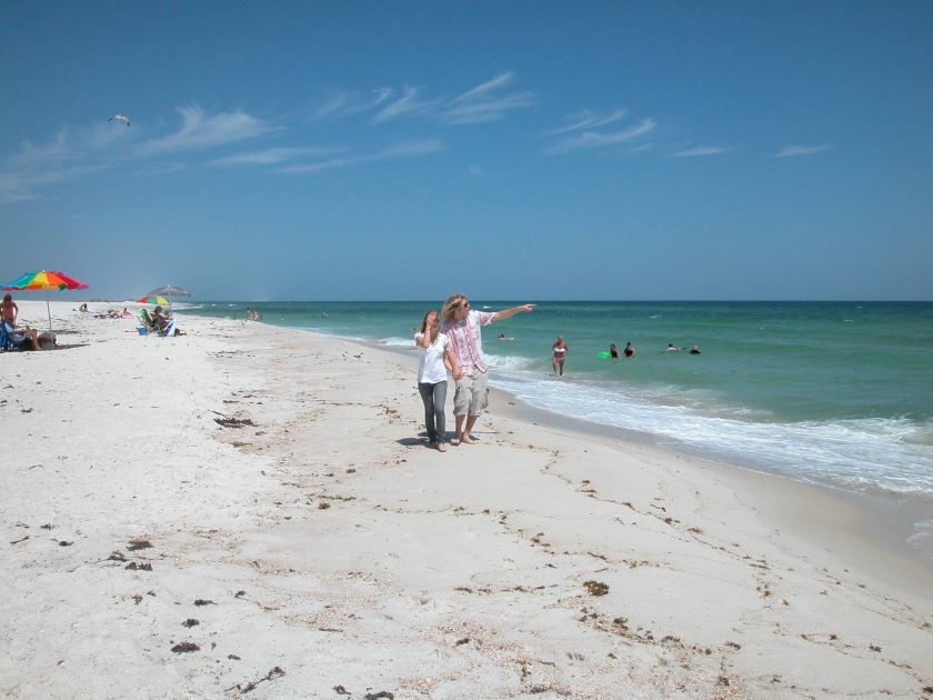 Woman pointing out to the ocean while walking on the Gulf Islands National Seashore