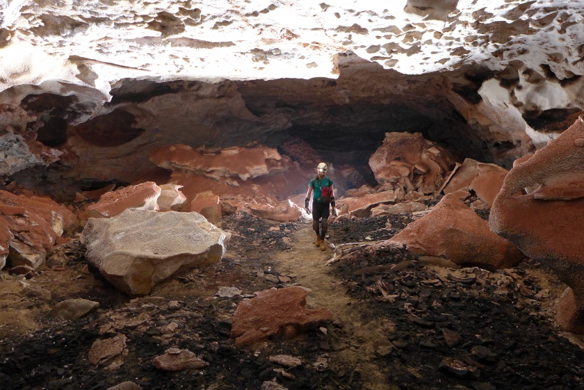 Caver standing in a large passage on an exploration trip
