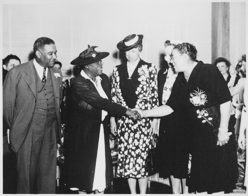 Imagen blanco y negro de Mary McLeod sacude las manos con las mujeres