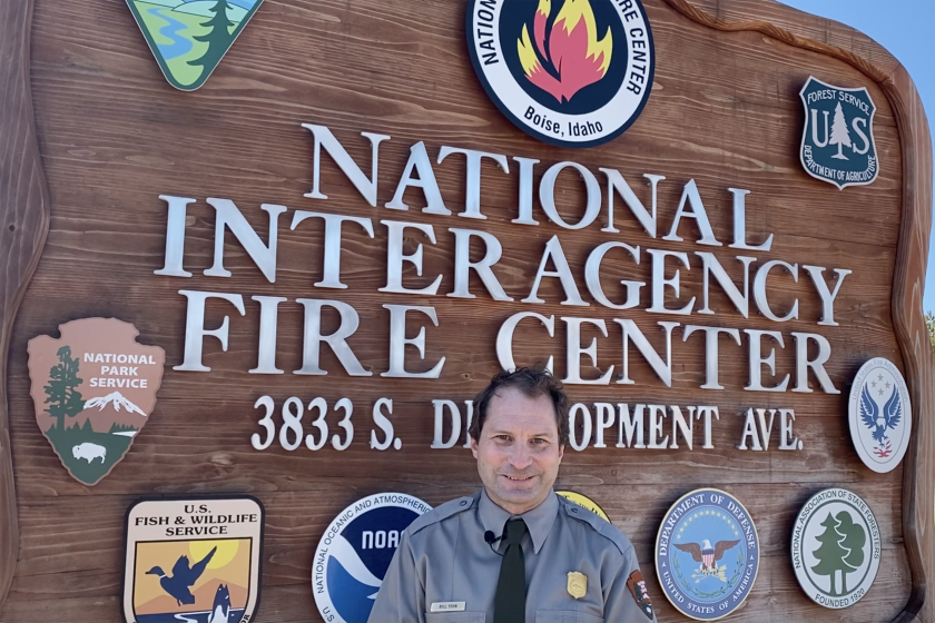 Bill Yohn poses in front of the sign at the National Interagency Fire Center